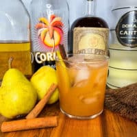 Rum Punch with rum bottles, pears, and cinnamon sticks
