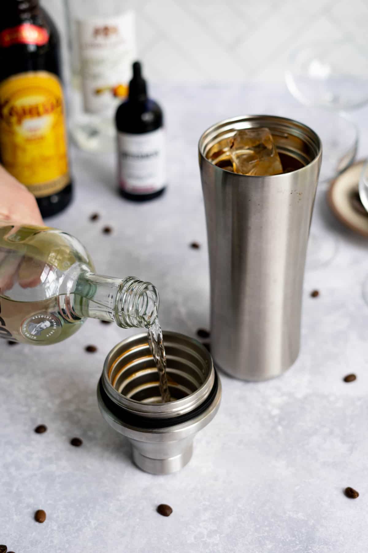 measuring vanilla vodka into cocktail shaker for a chocolate espresso martini.