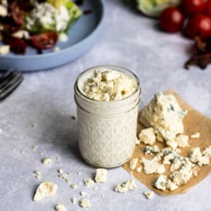 feature image of Greek yogurt blue cheese dressing, surrounded by crumbled blue cheese.