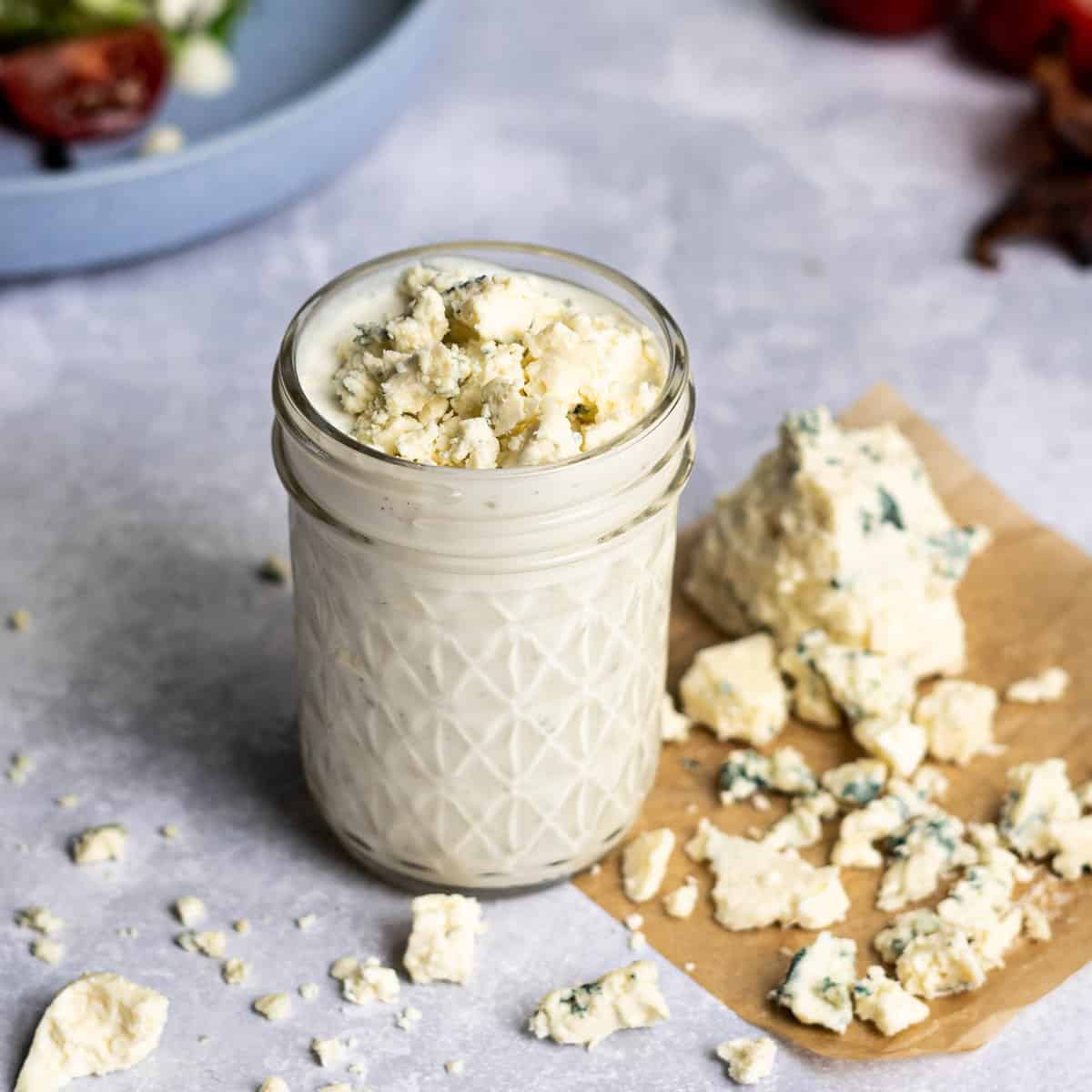 feature image of Greek yogurt blue cheese dressing, surrounded by crumbled blue cheese.