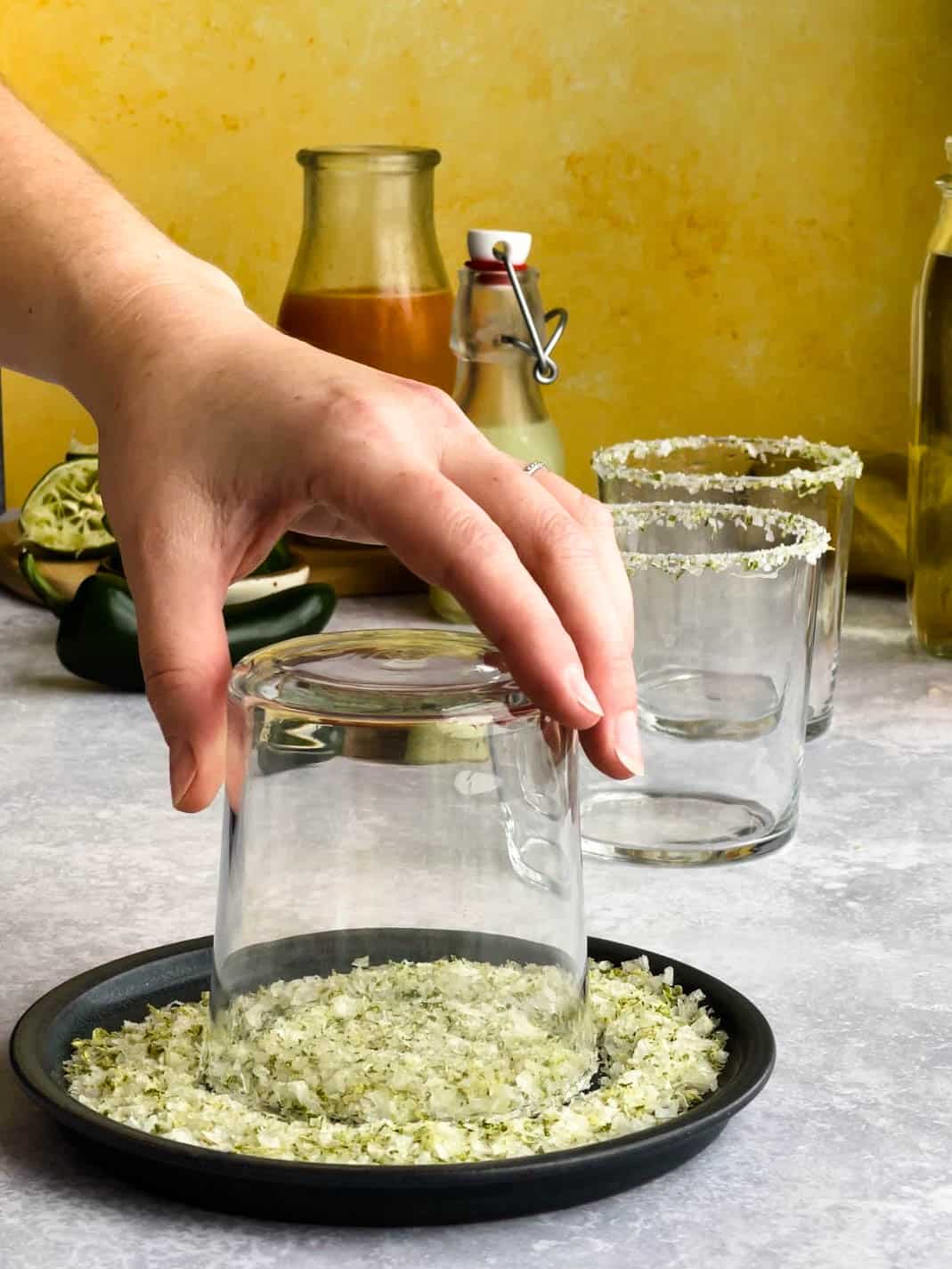 a cocktail glass is being rimmed with salt to garnish the edges for margaritas.