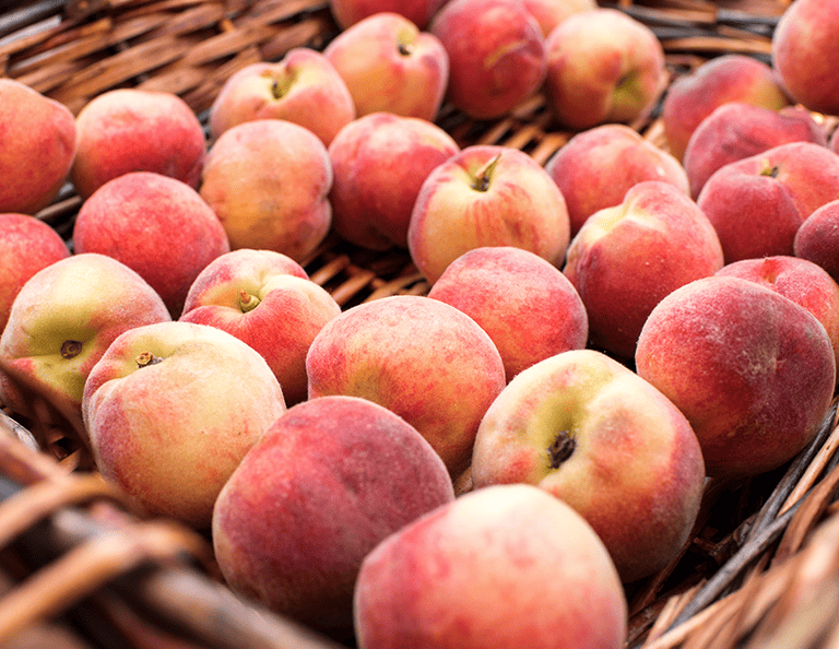produce in season in august, peaches in a basket