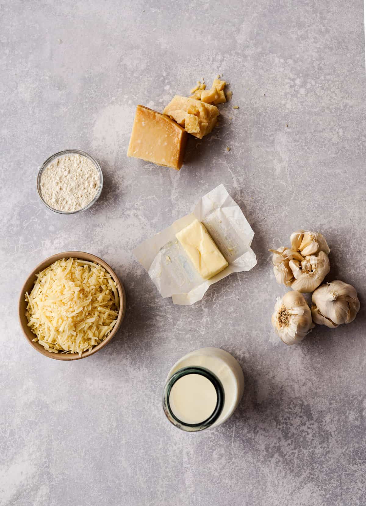ingredients used to make garlic parmesan sauce sit on a countertop.