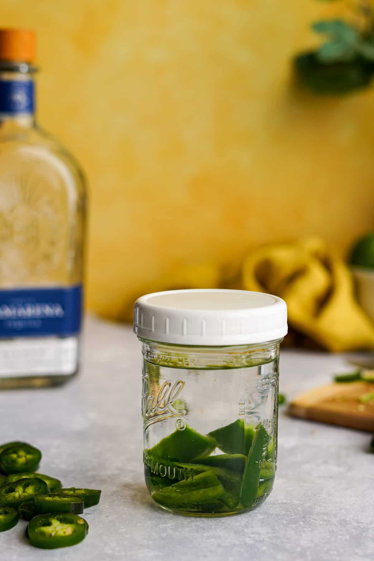 a filled jar of jalapeno infused tequila is ready to be aged.
