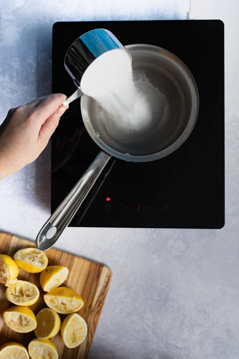 Step 3 in making homemade lemon simple syrup: combining 1.5 cups sugar with ½ cup of water.