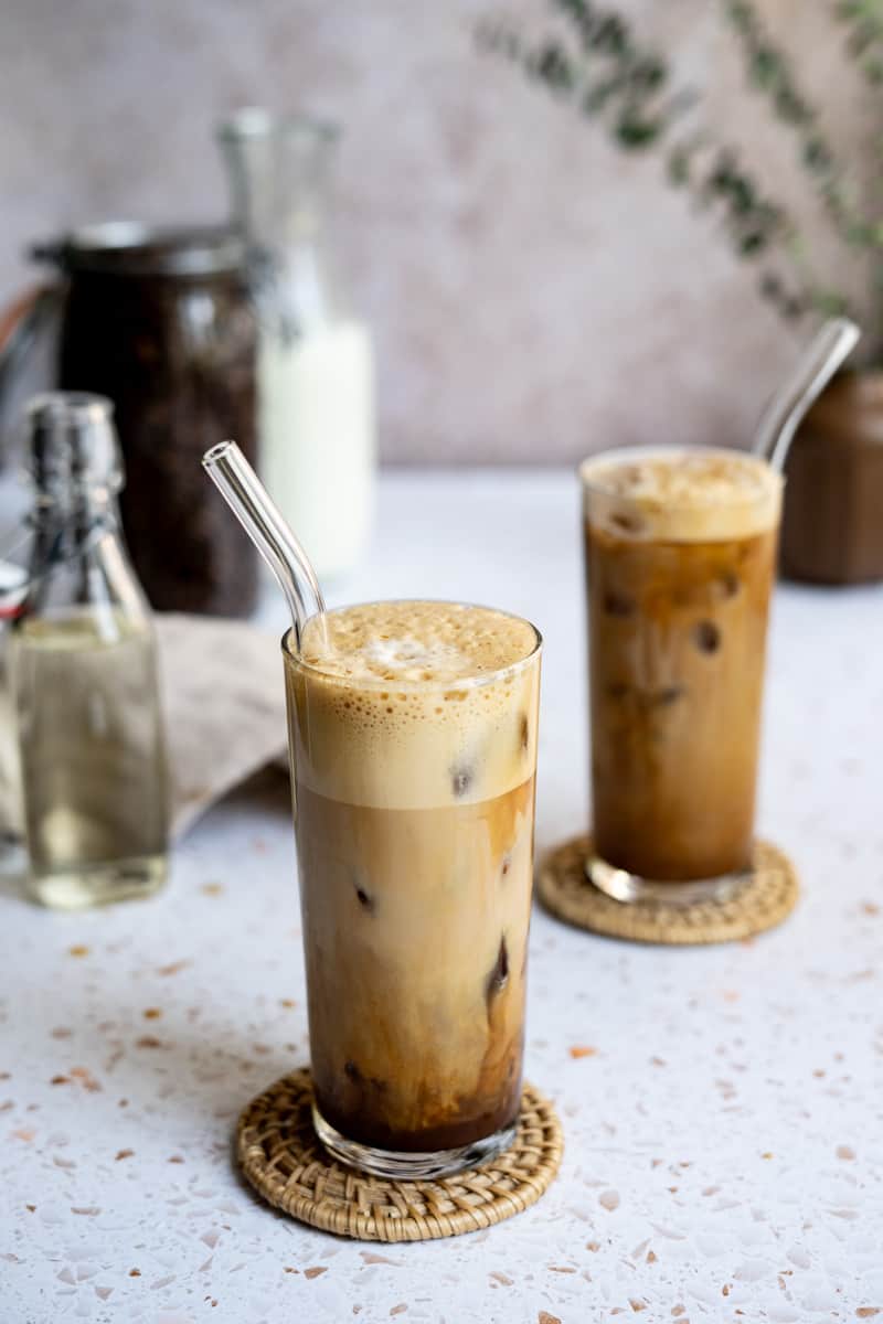Feature image of a double shot iced shaken espresso. Two glasses of the espresso beverage sit on a terrazzo countertop.