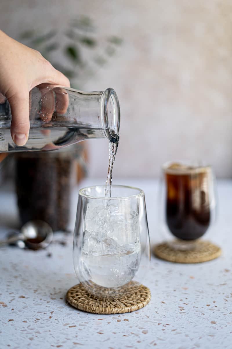 Step 3 of making an iced Americano: Pour in about 6-8 ounces of water, leaving about 2 inches of room for your espresso.