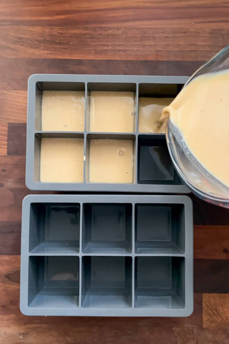 Step 6 of making iced pumpkin spice latte coffee cubes: filling ice cube trays half full with the pumpkin spice mix.