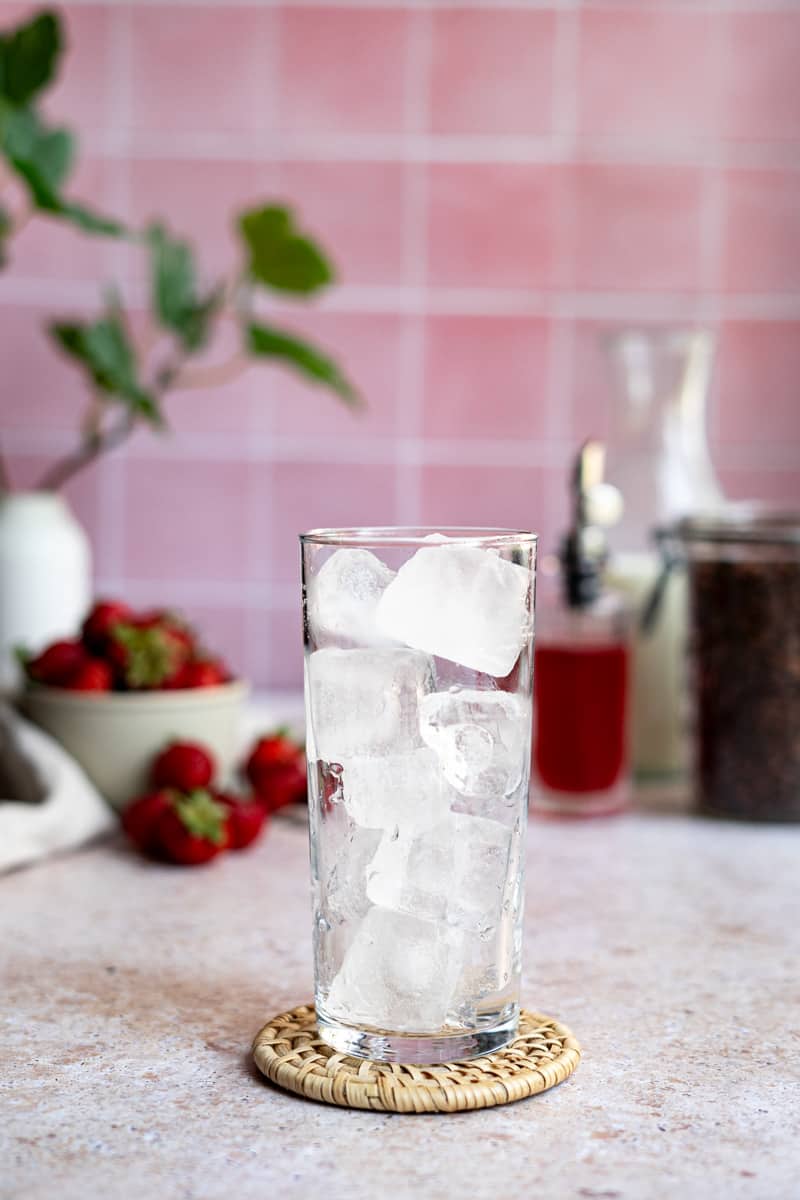 Step 2 of making an iced strawberry latte: Fill your preferred glass with ice.