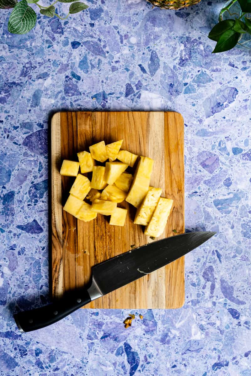 step 5 in making pineapple simple syrup: cutting the pineapple into 1-inch chunks.