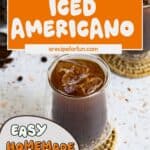 A glass of iced Americano coffee on a woven coaster, brimming with ice cubes and dark brew, with text overlays sharing an easy homemade iced Americano coffee recipe.