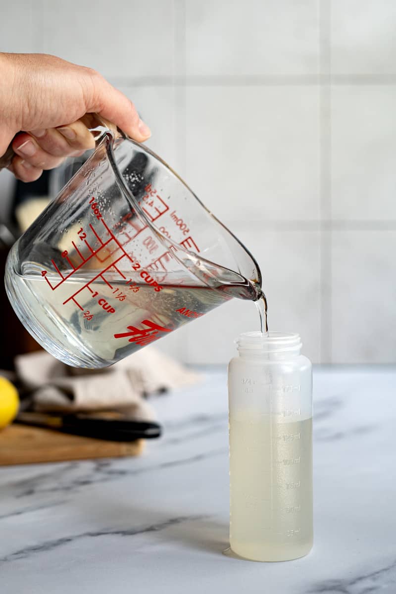 Pouring the simple syrup into a storage container.
