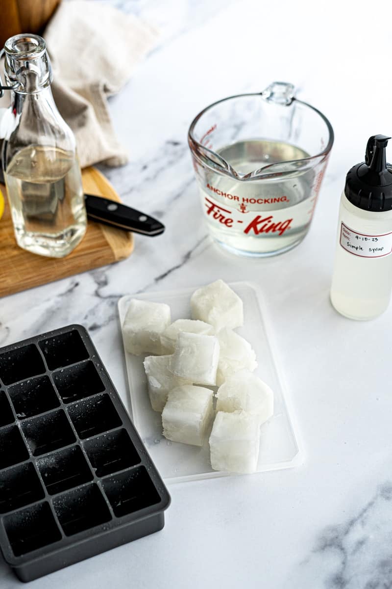 A pile of frozen simple syrup ice cubes sits on a countertop.