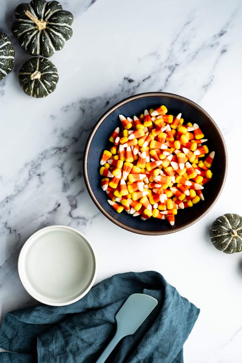 Ingredients used to make candy corn simple syrup sit on a marble countertop.