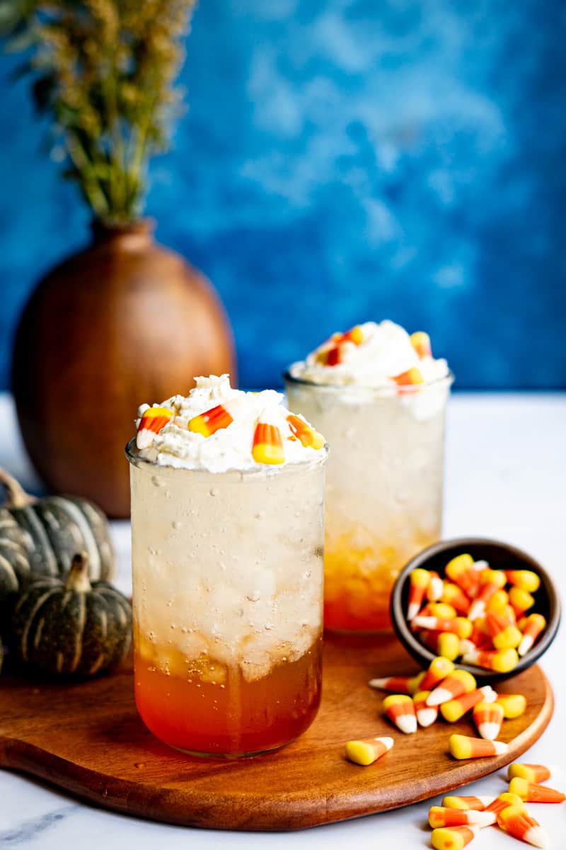 A candy corn soda is garnished with candy corn.