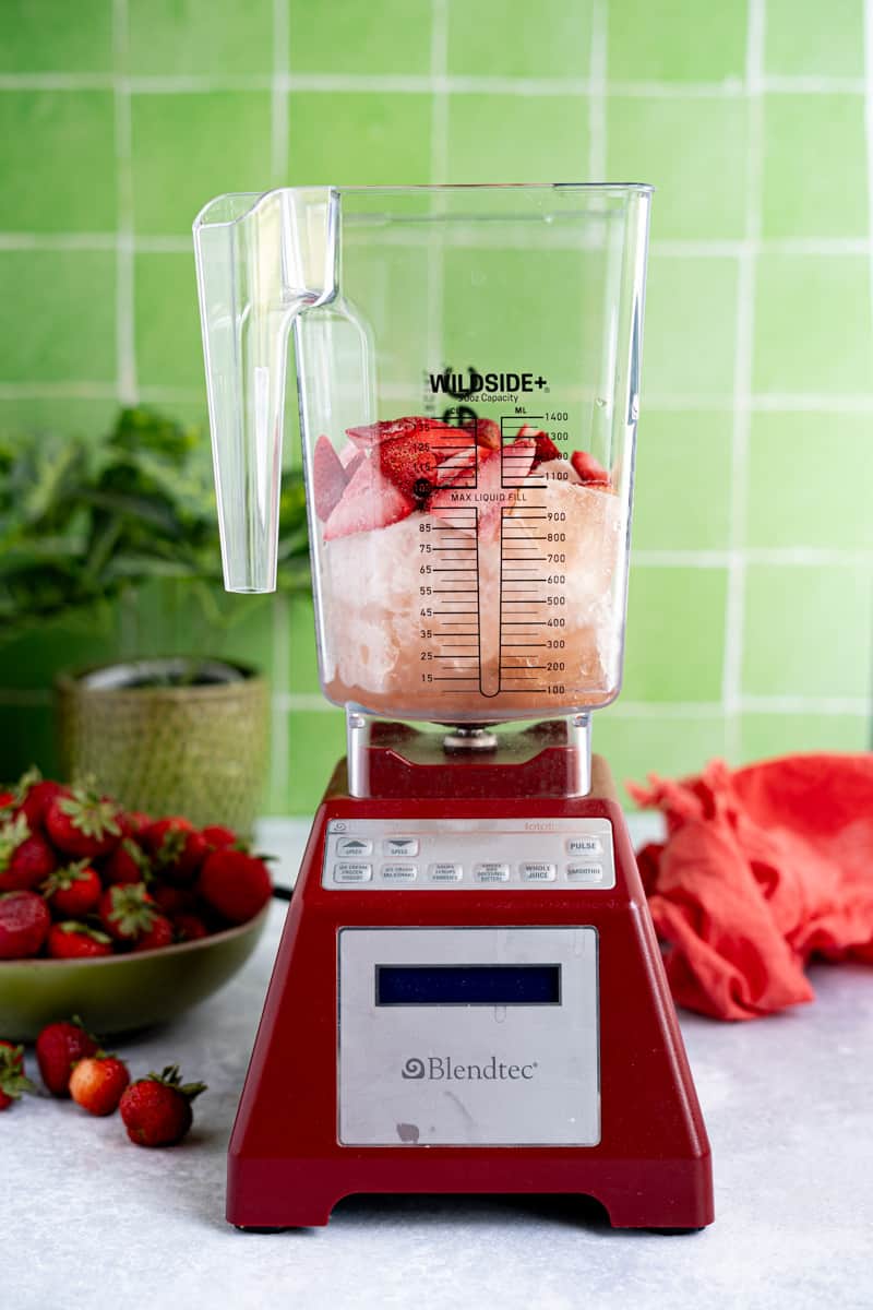 Step 4 of making frozé: Add frozen strawberries to the jar of a blender.