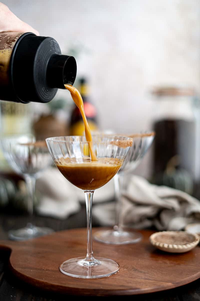Pouring a pumpkin espresso martini into a cocktail coupe.