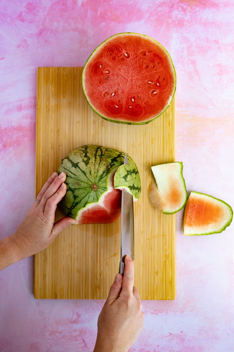 Cutting the rind off of a watermelon in preparation of making watermelon infused tequila.
