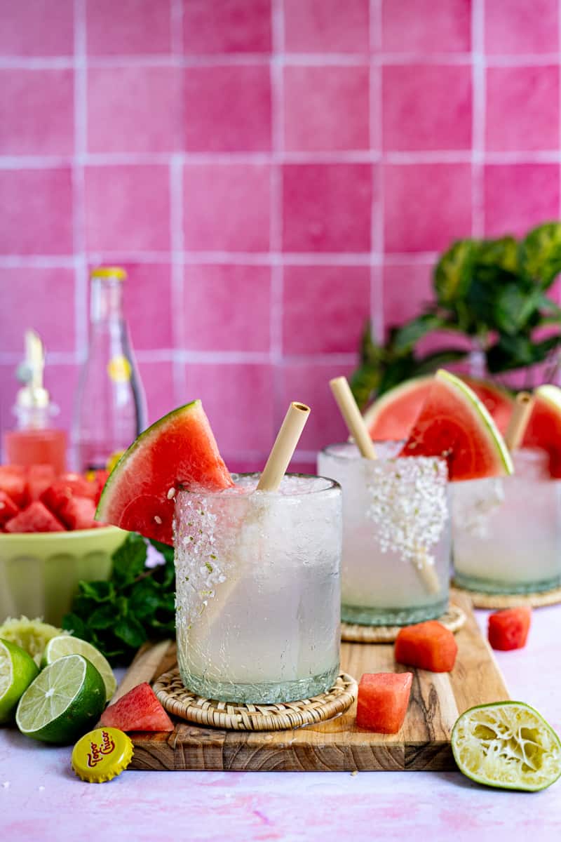 Three glasses of watermelon ranch water sit on a countertop ready to be served.