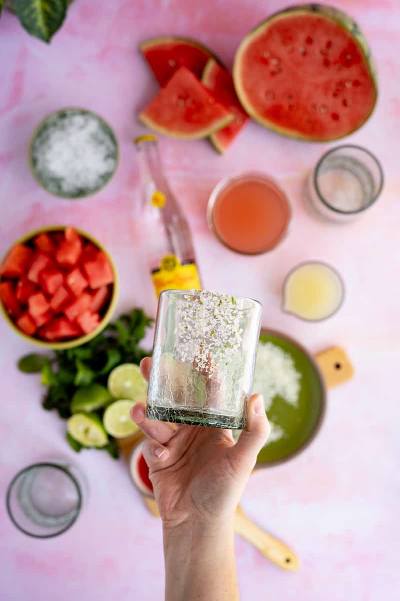 Showing off an optional garnish of lime salt on a cocktail glass for watermelon ranch water.