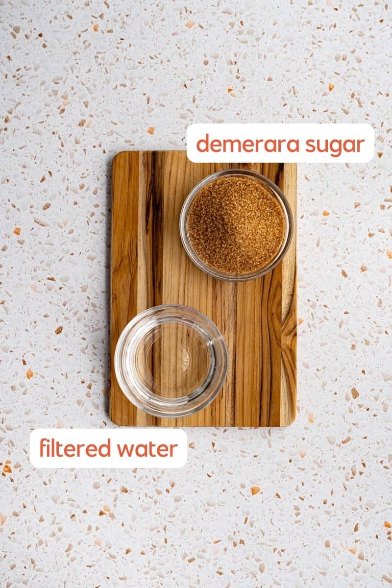 The ingredients used to make demerara simple syrup sit in small bowls on a wooden cutting board.