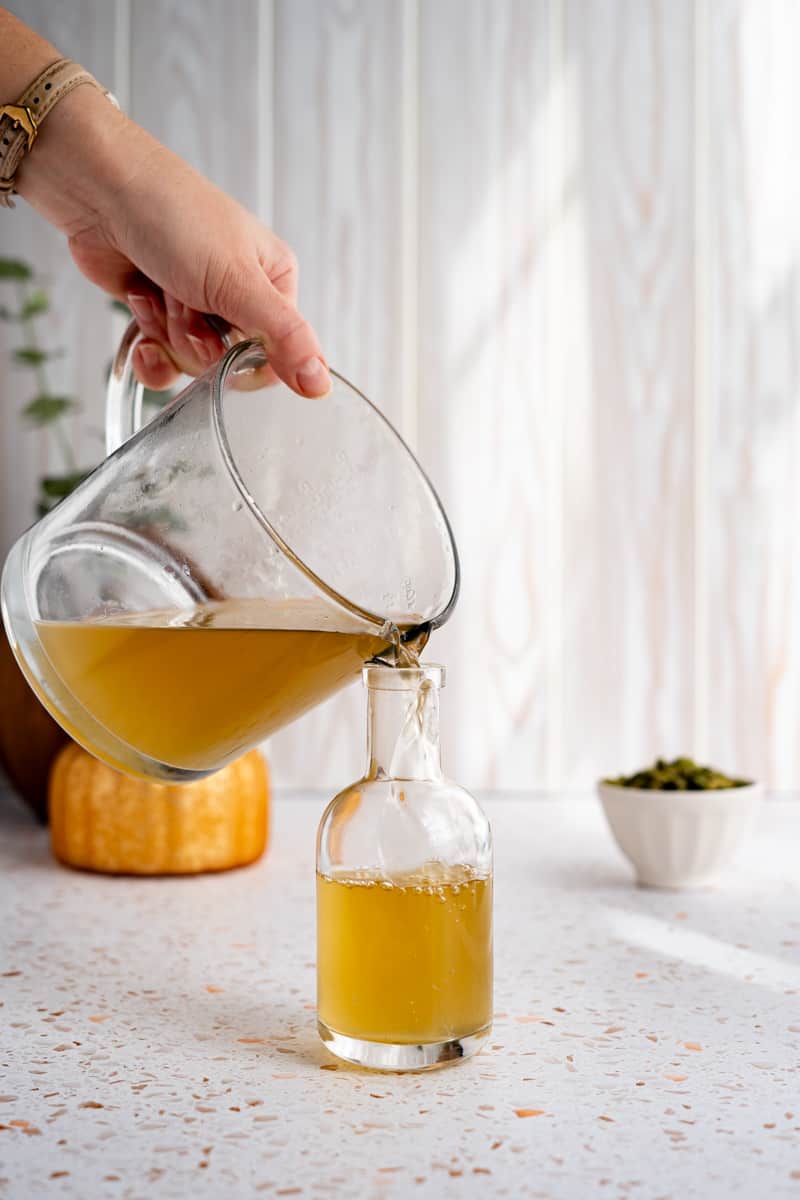 Pouring the simple syrup into an airtight storage container.