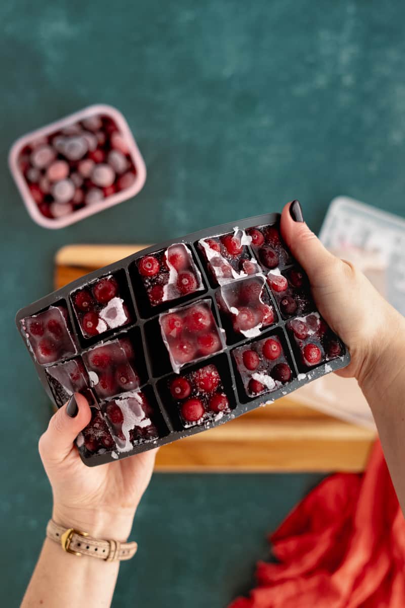 Removing the ice cube trays from the freezer and showing the frozen cubes.