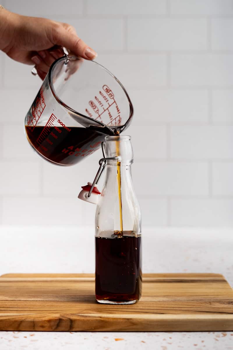 Pouring the finished syrup into a bottle for storage.