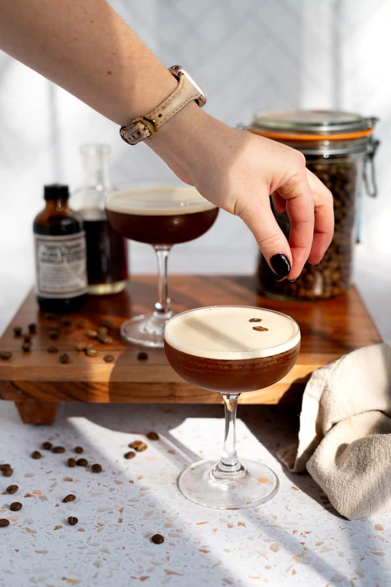 garnishing an espresso martini mocktail with three espresso beans.