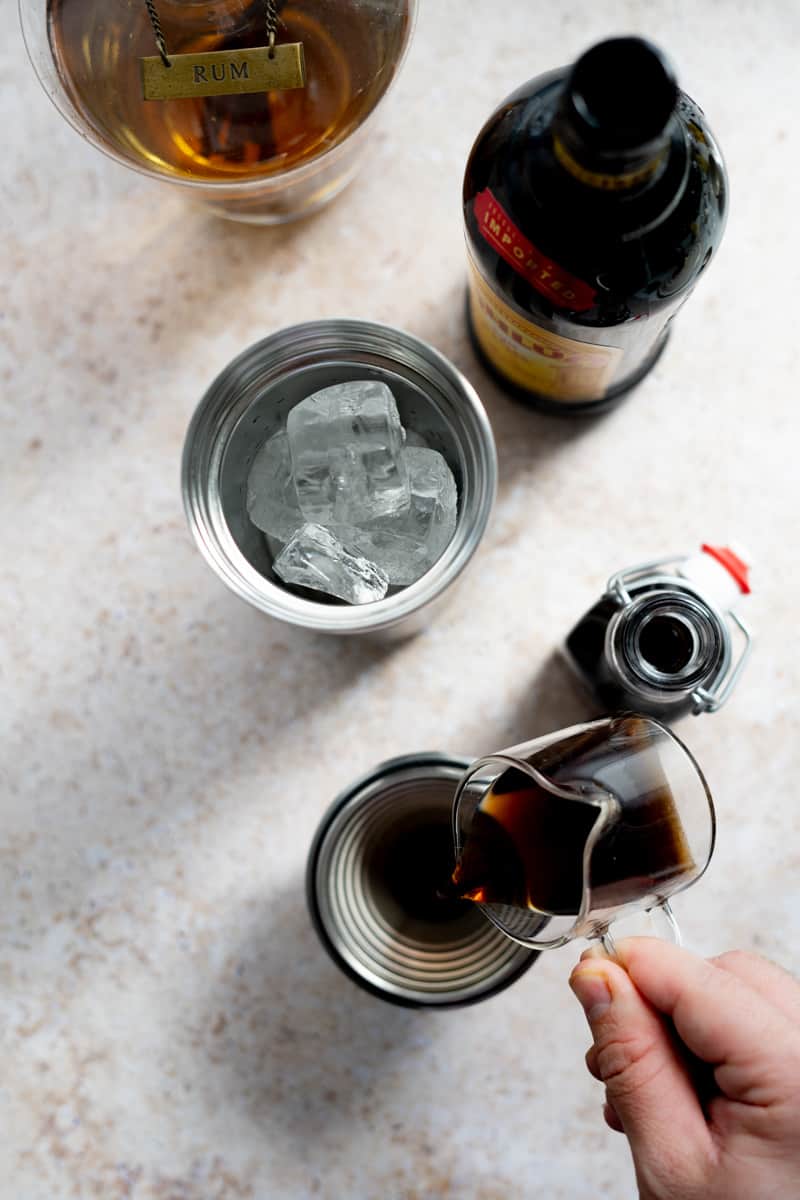 Step 2 of making a rum espresso martini: Pouring espresso into a cocktail shaker.