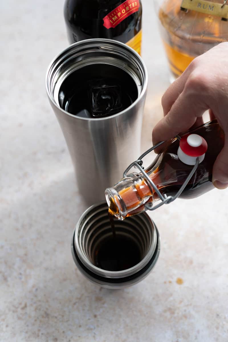 Step 5 of making a rum espresso martini: adding the brown sugar simple syrup into the cocktail shaker.
