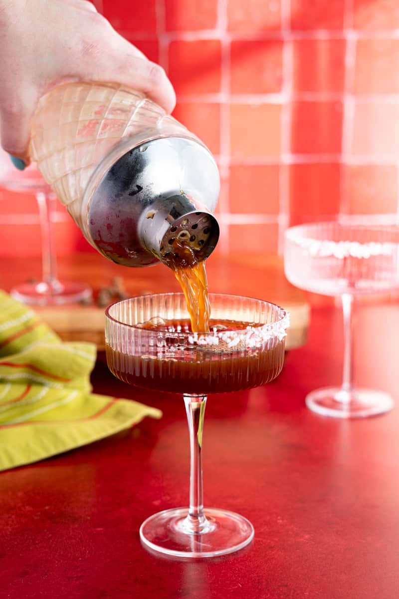 Straining a peppermint espresso martini into a cocktail coupe.