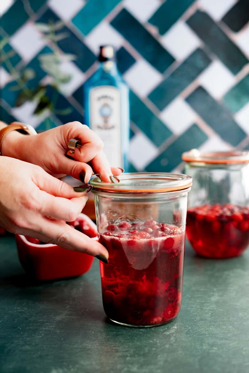 Sealing the jar with cranberries and gin.