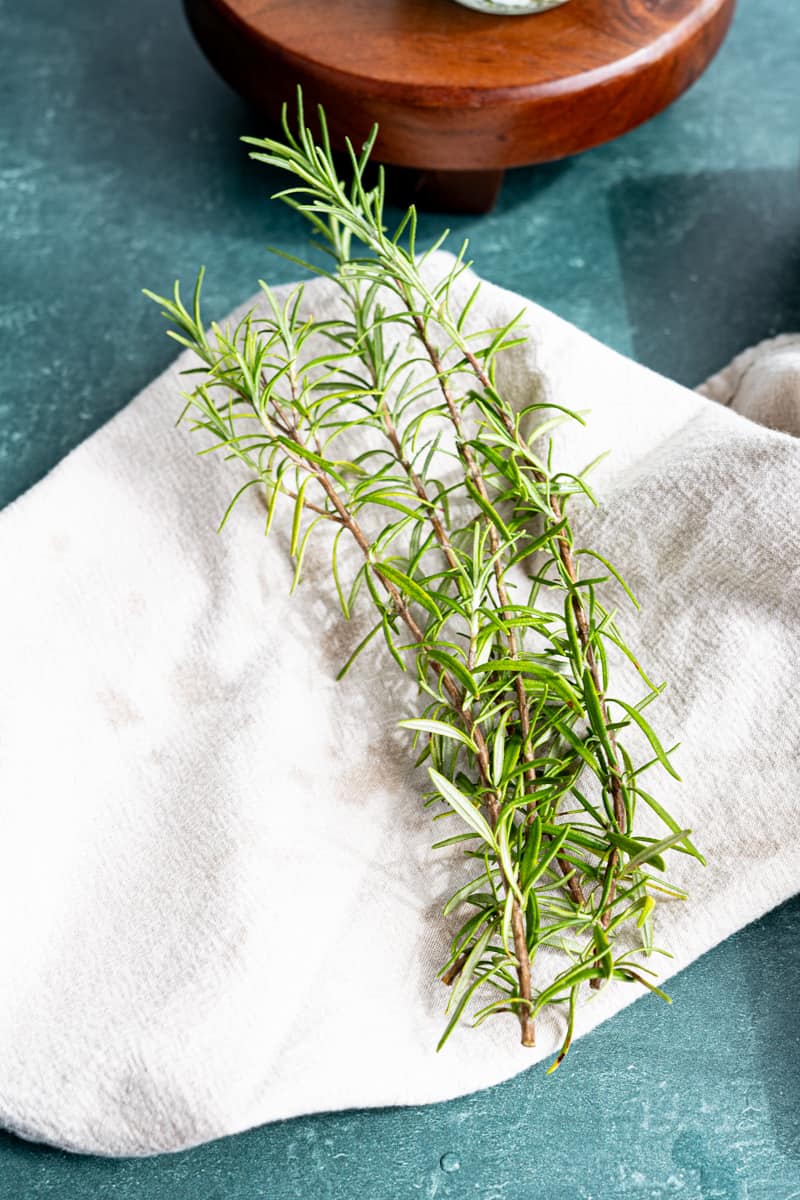 Rinsing and drying fresh sprigs of rosemary.