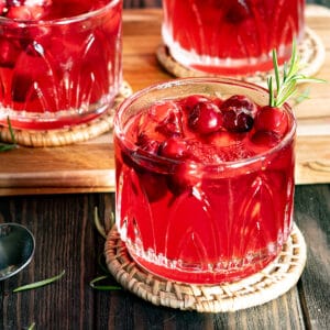 A cranberry gin smash cocktail sits on a wooden