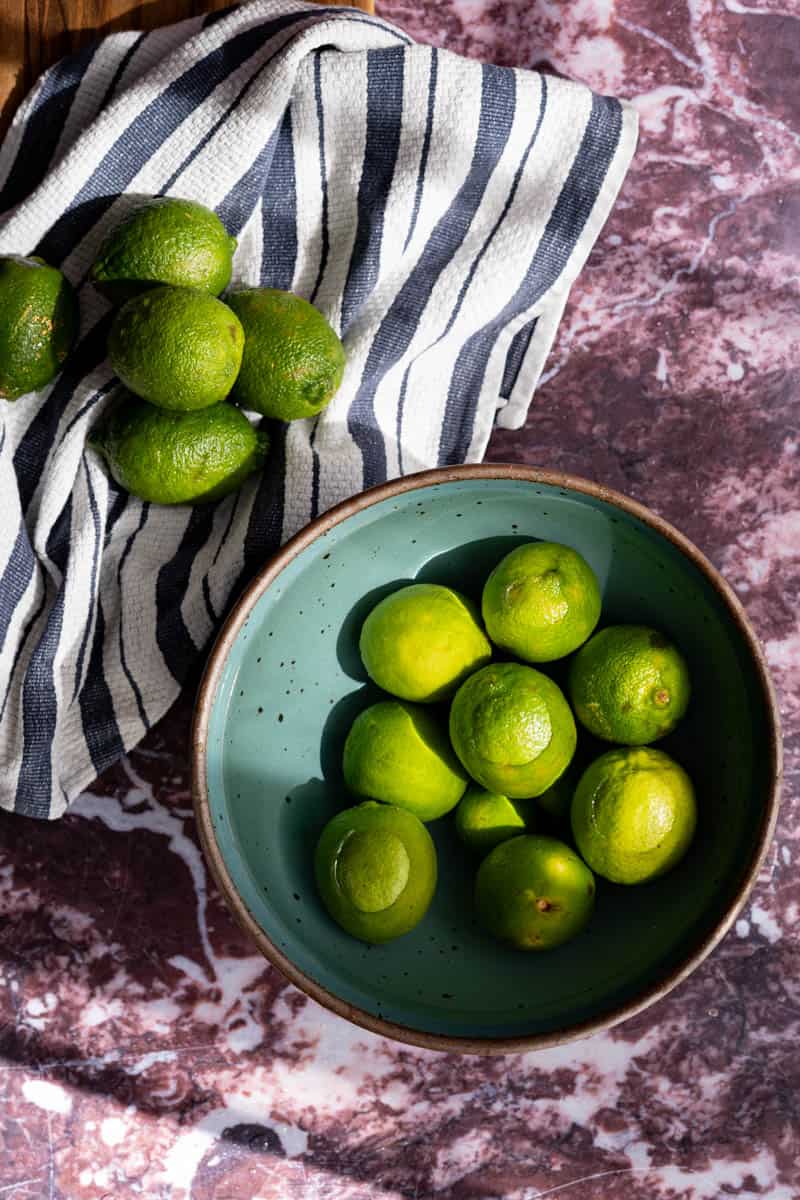 Washing limes in a bowl of water.
