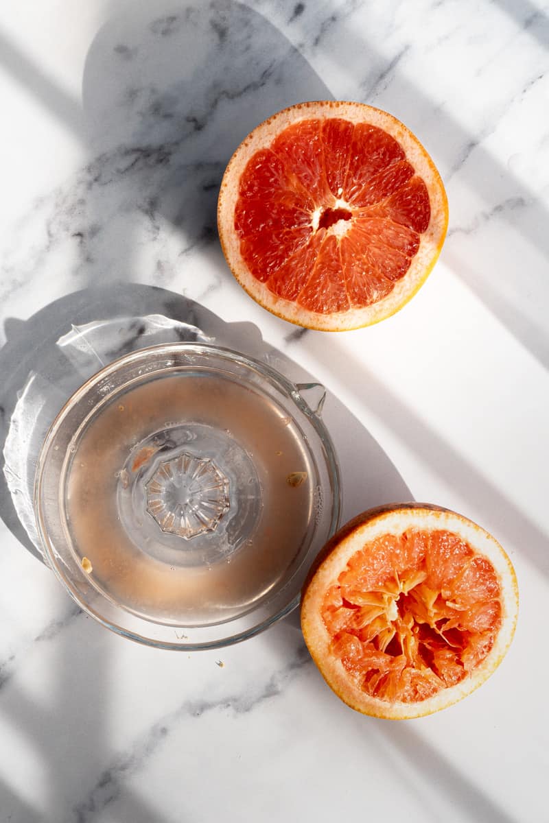 Grapefruit has been sliced in half and juiced to make homemade grapefruit simple syrup.