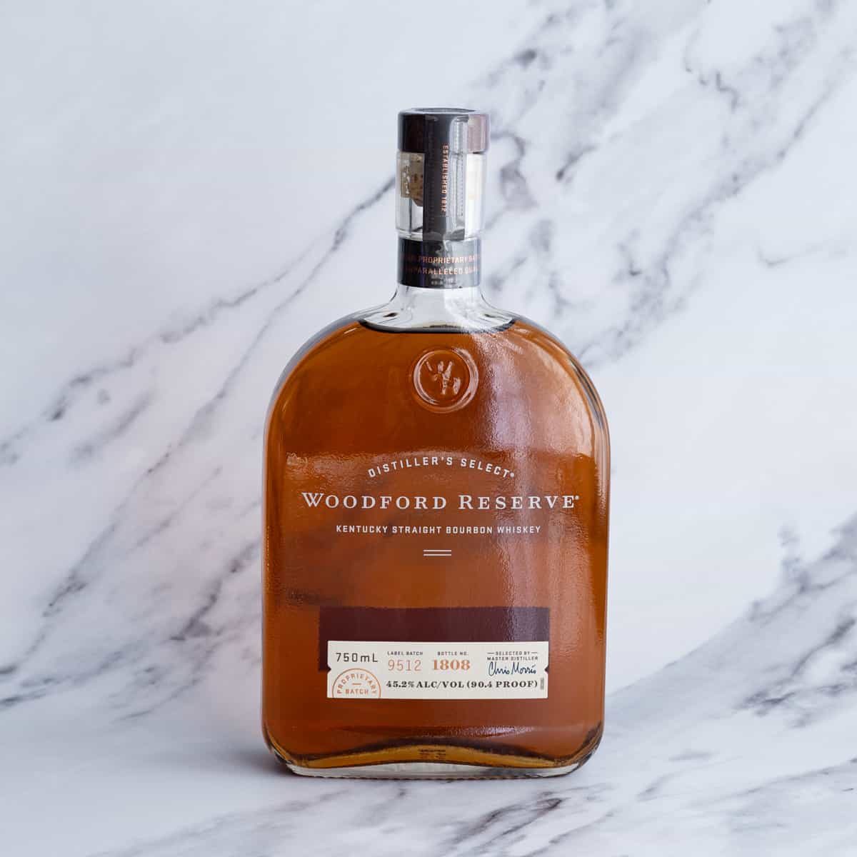 Bourbon whiskey sits on a marble countertop.
