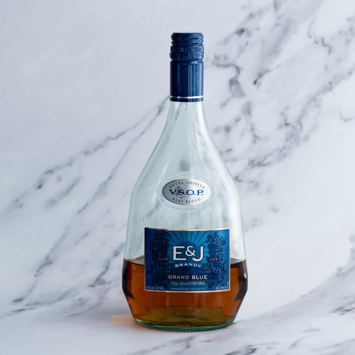 A bottle of brandy sits on a marble countertop.