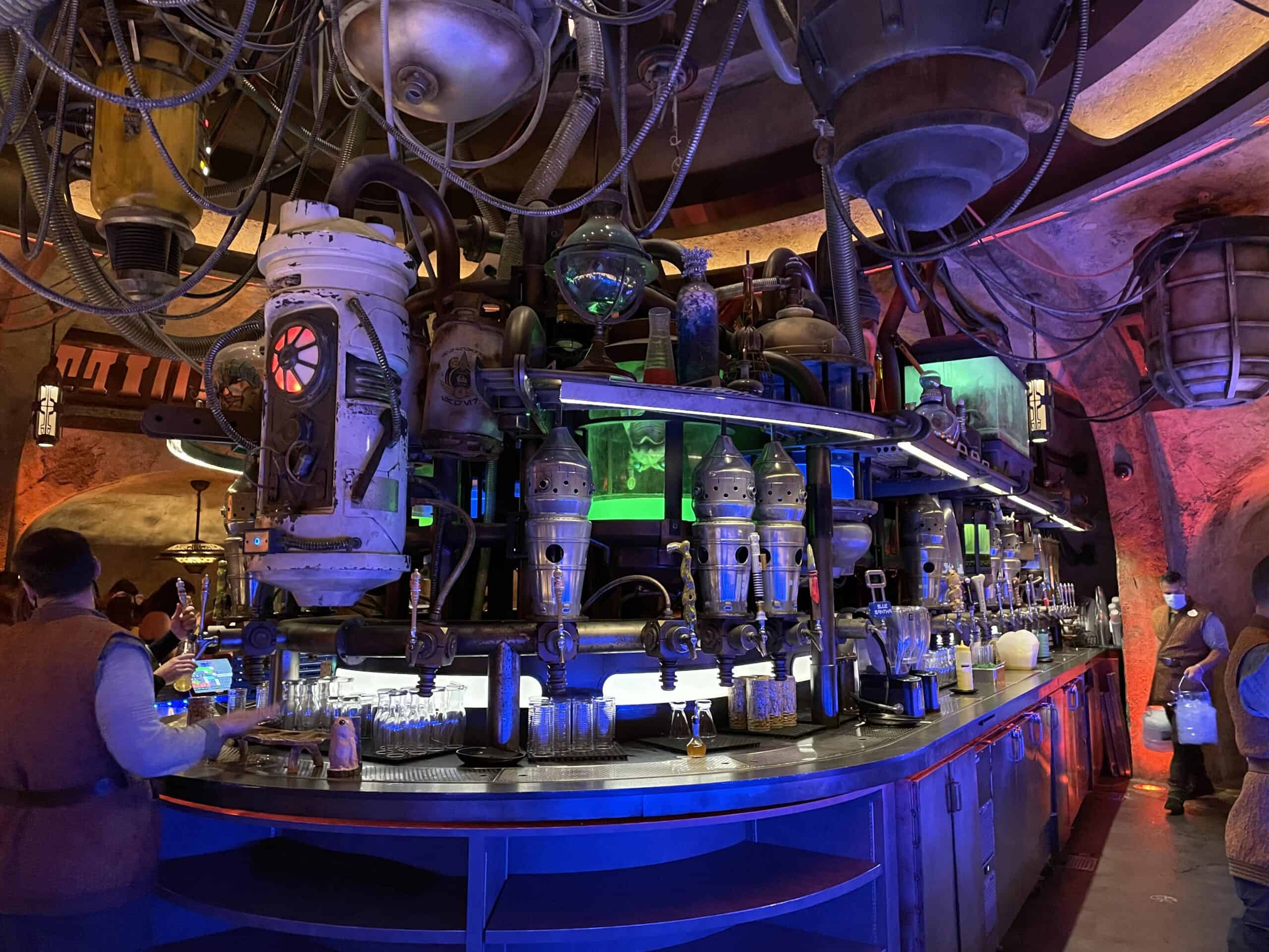 Oga's Cantina on Batuu in Star Wars Galaxy's Edge is a bar with many machines and lights, serving the famous Dagobah Slug Slinger.