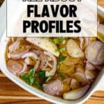 A baking dish filled with sliced shallots, herbs, and a marinade sits on a wooden surface. Text reads: “All About Flavor Profiles” and “learn how to be an intuitive cook at home using flavor profiles!”.