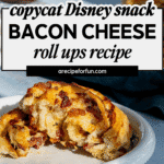 A plate with a bacon and cheese rolls close up sits on a blue table, with a blurred cup of tea in the background. Text on the image advertises a copycat Disney snack bacon cheese roll ups recipe.