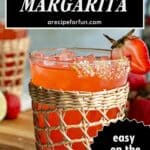 A vibrant strawberry margarita on the rocks in a woven glass, garnished with a strawberry and sugar rim. Text reads: Strawberry Margarita, arecipeforfun.com, easy on the rocks cocktail!.